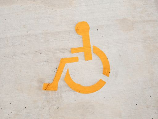 A closeup shot of a yellow handicapped sign painted on the wall