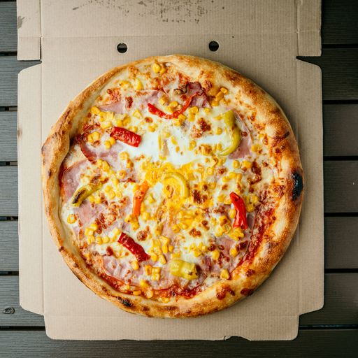 A vertical closeup of the pizza with sweet corn, red peppers, ham and egg.