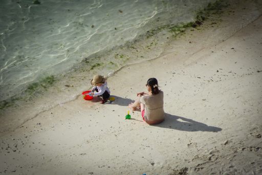 An aerial view of two kids playing on the Tumon Bay beach  of Guam near water