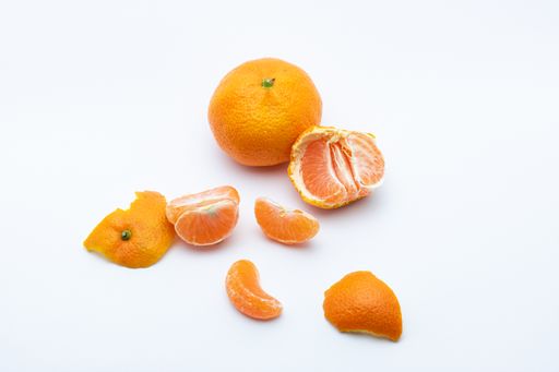 A photo of tangerine and tangerine slices isolated on a white background