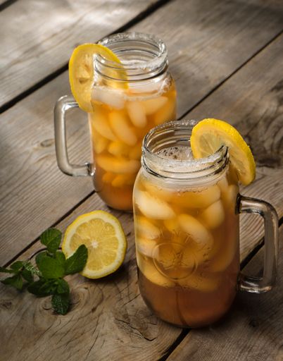 A vertical shot of two jars of a lemon juice on a wooden surface