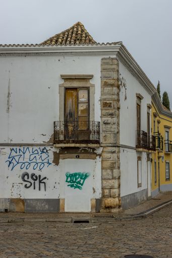 The old buildings of Faro with graffiti during a rainy day in Portugal