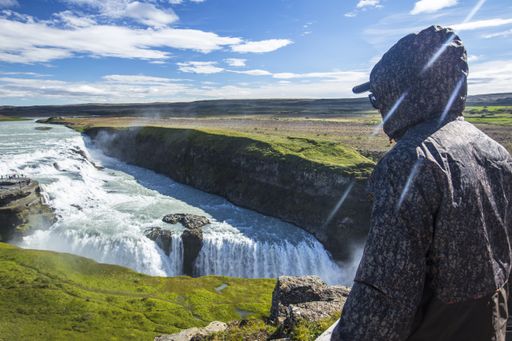 A closeup shot of a male enjoying Gullfoss waterfall in Iceland