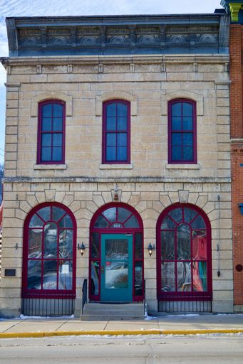 A vertical shot of a beautiful store with red and green windows