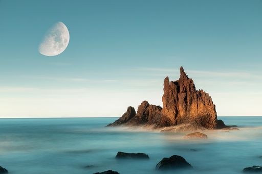 A white half moon in a blue sky over Playa de Benijo, Tenerife, Canary Islands