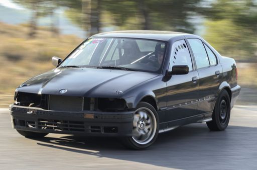 A black Modified and tuned BMW E34 for drifting on the track with motion in the background in Barcelona, Spain