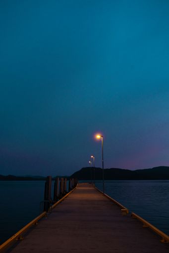 A lonely portrait of an empty wooden dock captured at night