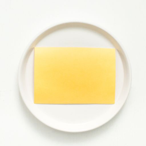A vertical closeup shot of a blank yellow sheet for your text on a white plate