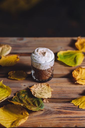 A vertical shot of hot cocoa with whipped cream and cinnamon on top
