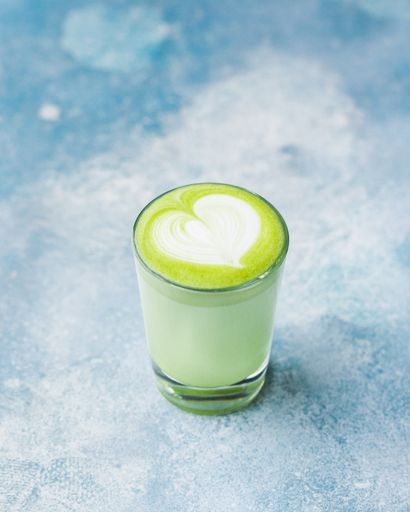 A vertical selective closeup shot of a glass of matcha drink