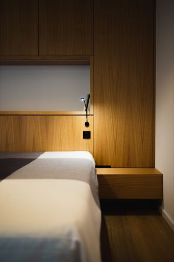A vertical shot of the modern bedroom design in brown, gray, and white colors.