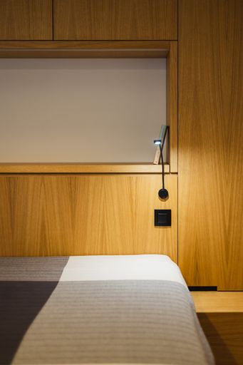 A vertical shot of the modern bedroom design in brown, gray, and white colors.