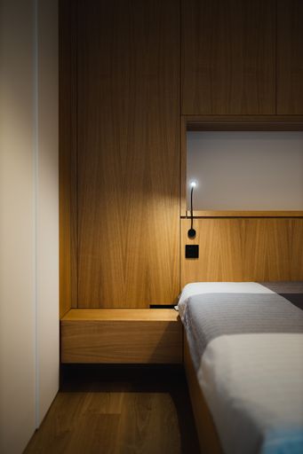 A vertical shot of the modern bedroom design in brown, gray, and white colors.