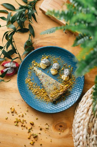 A vertical closeup of the piece of pistachio cheesecake tart with dragonfruit.