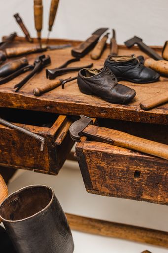 A vertical shot of different tools of a cobbler workplace