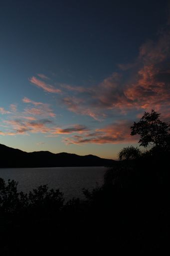 A vertical shot of a scenic colorful sunset over the blue tranquil ocean