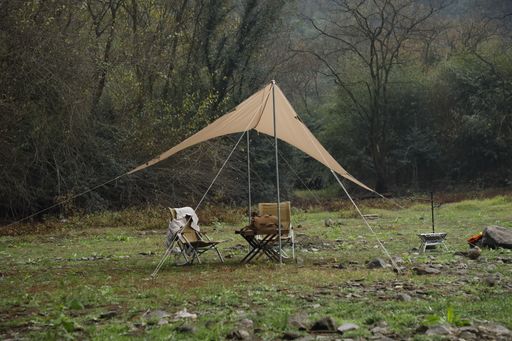A selective focus shot of a campsite in a clearing in the middle of a forest