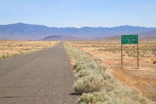 A rural traffic sign shows the distances to several locations in Nevada's desert interior.