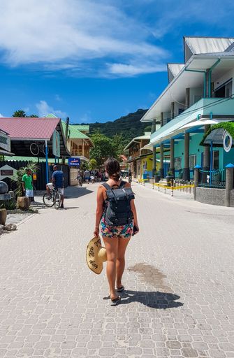 A closeup of a young girl walking in street of tropical town on La Digue island on Seychelles