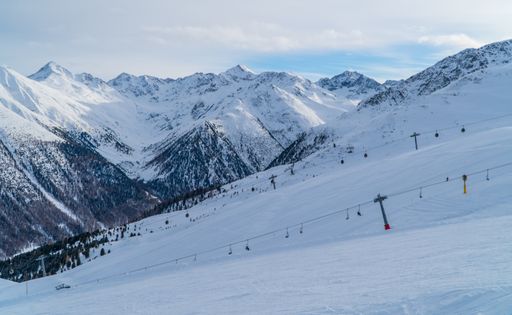 The skiers on a slopes chair lift in the town of Livigno in the Italian Alps on a moody day