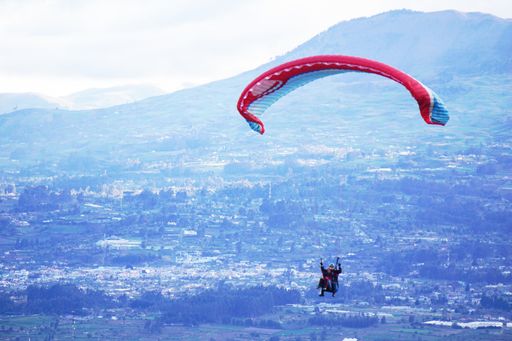 An aerial shot of paragliding over the beautiful landscape