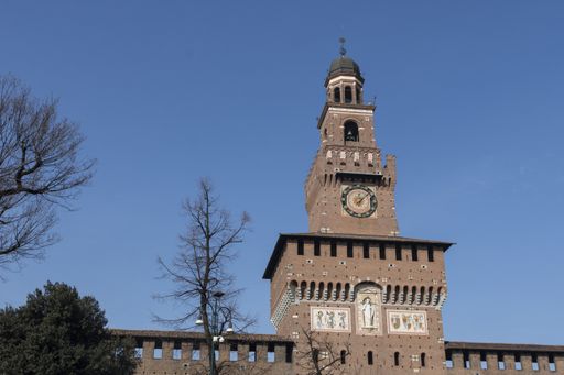 A low angle shot of medieval brick-made Sforza Castle under a blue clear sky in Milan, Italy