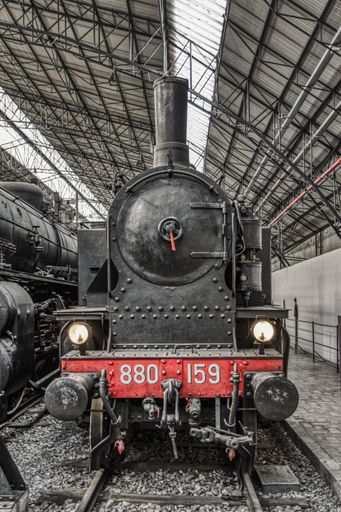 The old iron horses were huge black locomotive train engines with red details. Classic station from a century ago