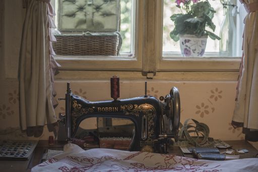 old sewing machine in an old house, is in front of the window to see better