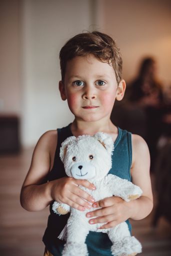 A beautiful shot of a Caucasian child holding a white bear
