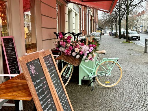 A view of bicycles with flowers parked in a street