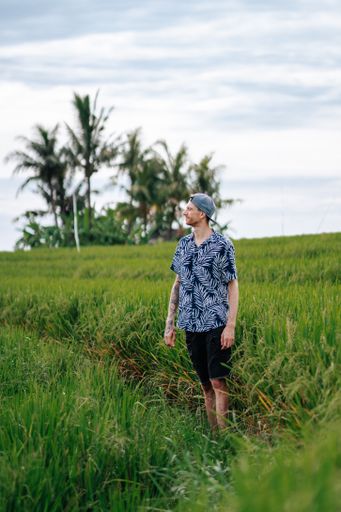 A caucasian man in a blue Hawaiian shirt standing in the oat field in Bali