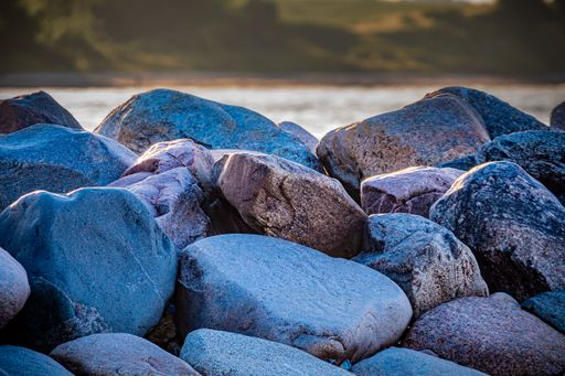A closeup shot of some rocks near a sea during the day