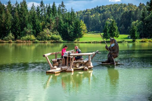 A couple tourist dining outdoors on a lake after a bike tour around Lake Bloke in Nova Vas, Slovenia