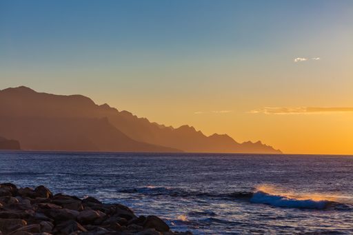 A landscape of the sea surrounded by rocky cliffs during a beautiful sunrise in Spain