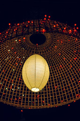 A low angle shot of a modern chandelier with garlands on a black background