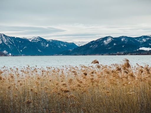 A beautiful shot of the Tegernsee lake surrounded by mountains under a cloudy sky