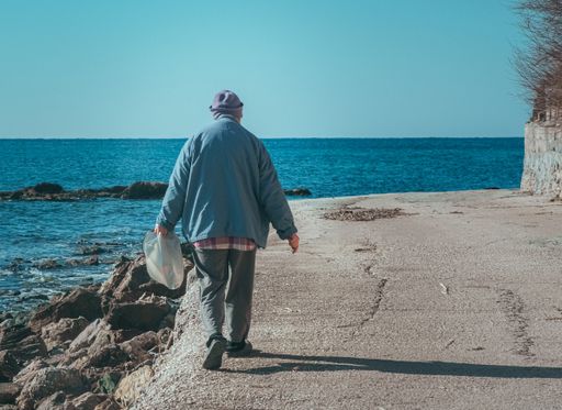 An old male walking on a seashore