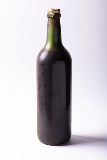 A closeup shot of a bottle of wine with a white background