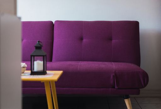 A modern interior with a purple sofa and a wooden table