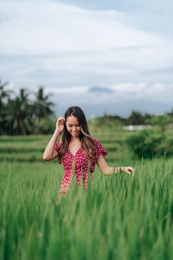 A vertical shot of an East Asian girl enjoying her time in a field.