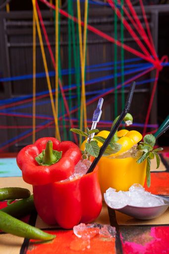 A beautiful vertical shot of red and yellow Bell pepper cocktail with a colorful blurry background