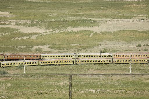 An aerial shot of an old rusty train on an abandoned railway