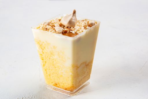 A closeup shot of yummy cheesecake dessert with little meringue on the top, served in a small plastic cup
