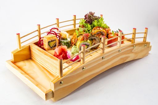 A closeup shot of delicious sushi set on a wooden stand in the form of the bridge isolated on white