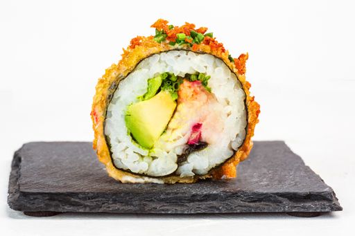 A closeup shot of delicious sushi roll with seasonings on white background