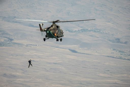 A paratrooper jumping out of a helicopter in the sky