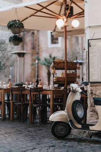 A picturesque shot of the motorbike parked on the old street in Rome, Italy