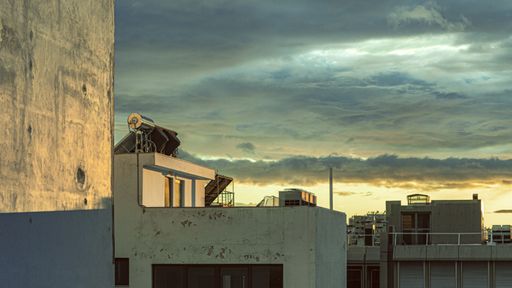 The residential buildings under a cloudy sky during the sunset in the evening in Piraeus, Greece