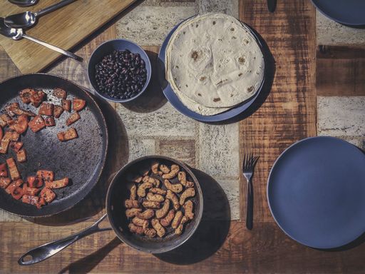 Directly above or flat lay shot of Mexican food with Tortilla, black beans, baked paprika and meat replacement vegan sticks.