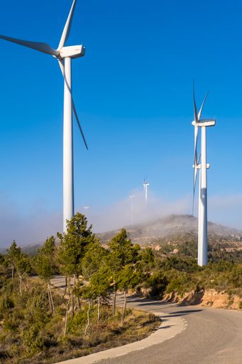 A road leads to the wind turbines area in Barcelona, Spain